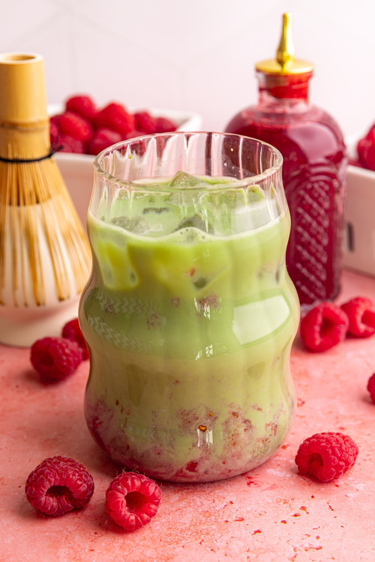An iced raspberry matcha latte, stirred.