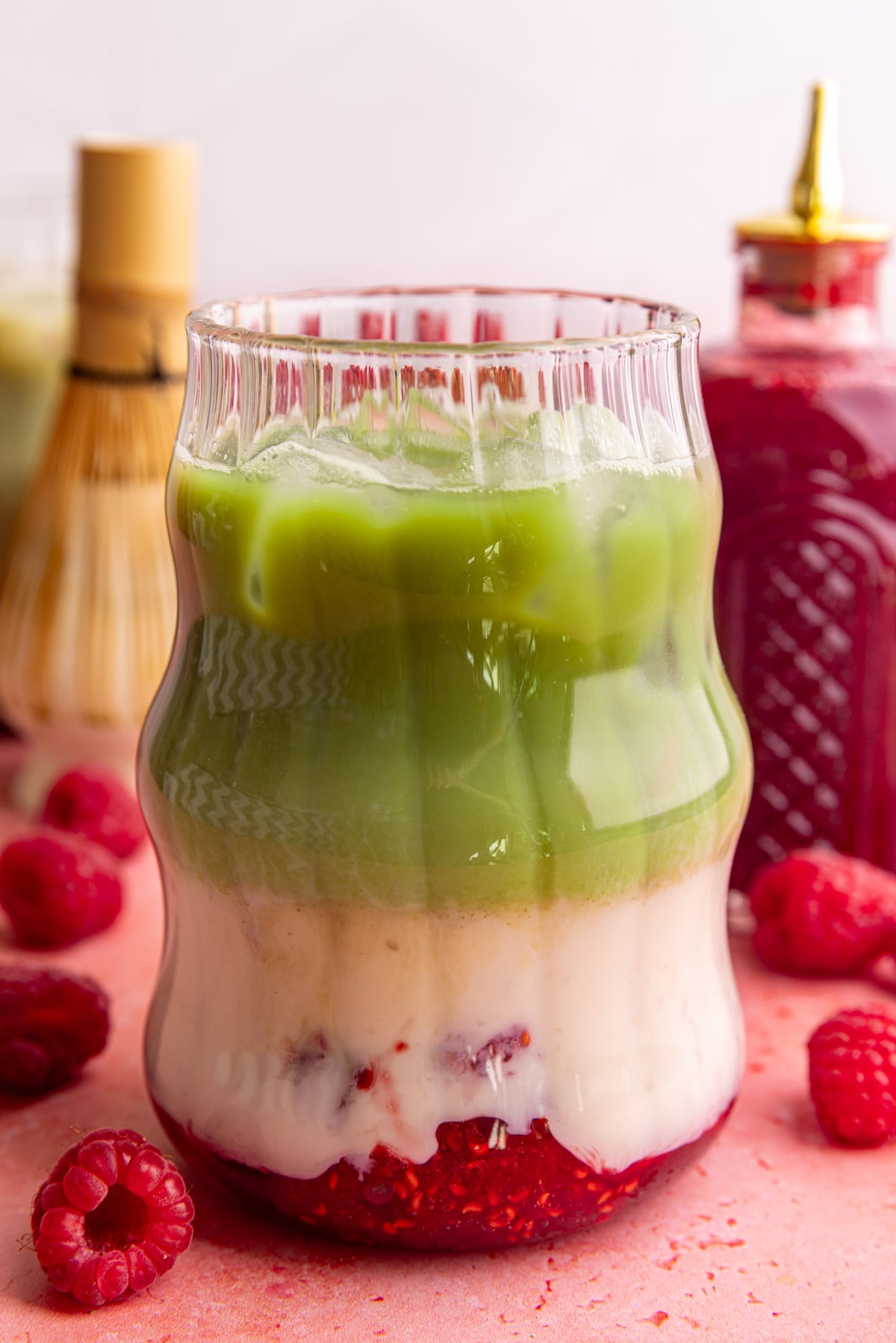 A raspberry matcha latte, with three distinct layers of raspberry, milk, and matcha.