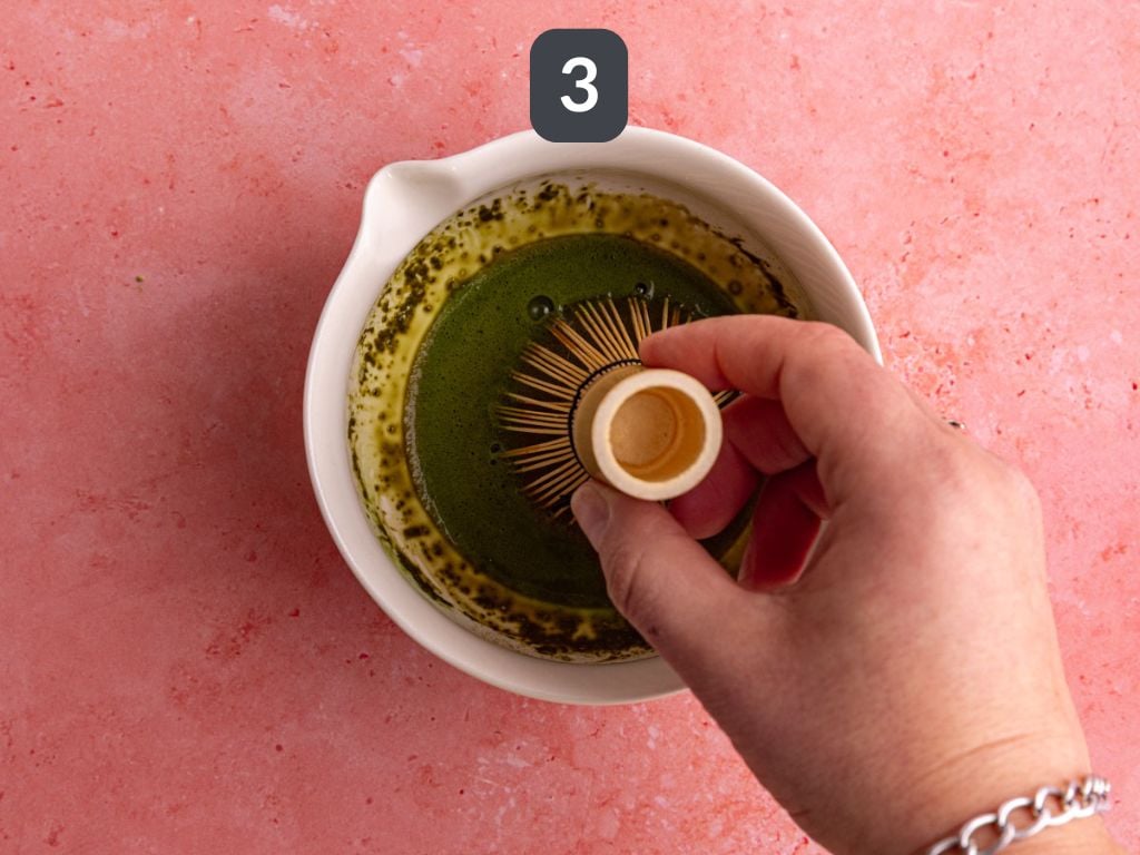 Raspberry matcha latte step 3 - add hot water and whisk.