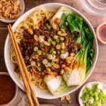 A bowl of Vegan Dan Dan noodles, with a pair of chopsticks, ready to eat.