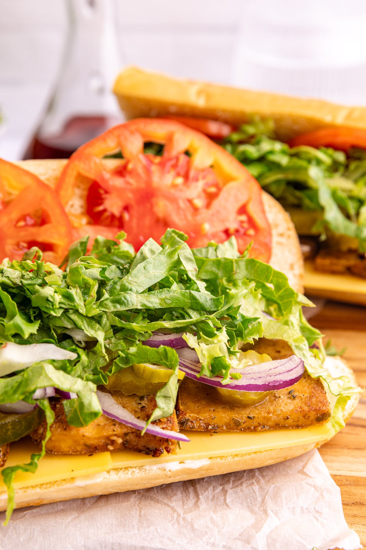 A vegan deli turkey sandwich on a baguette, with potato chips.