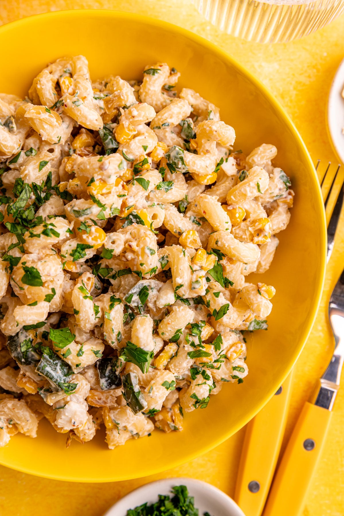 A bowl of vegan elote corn pasta salad, garnished with cilantro.
