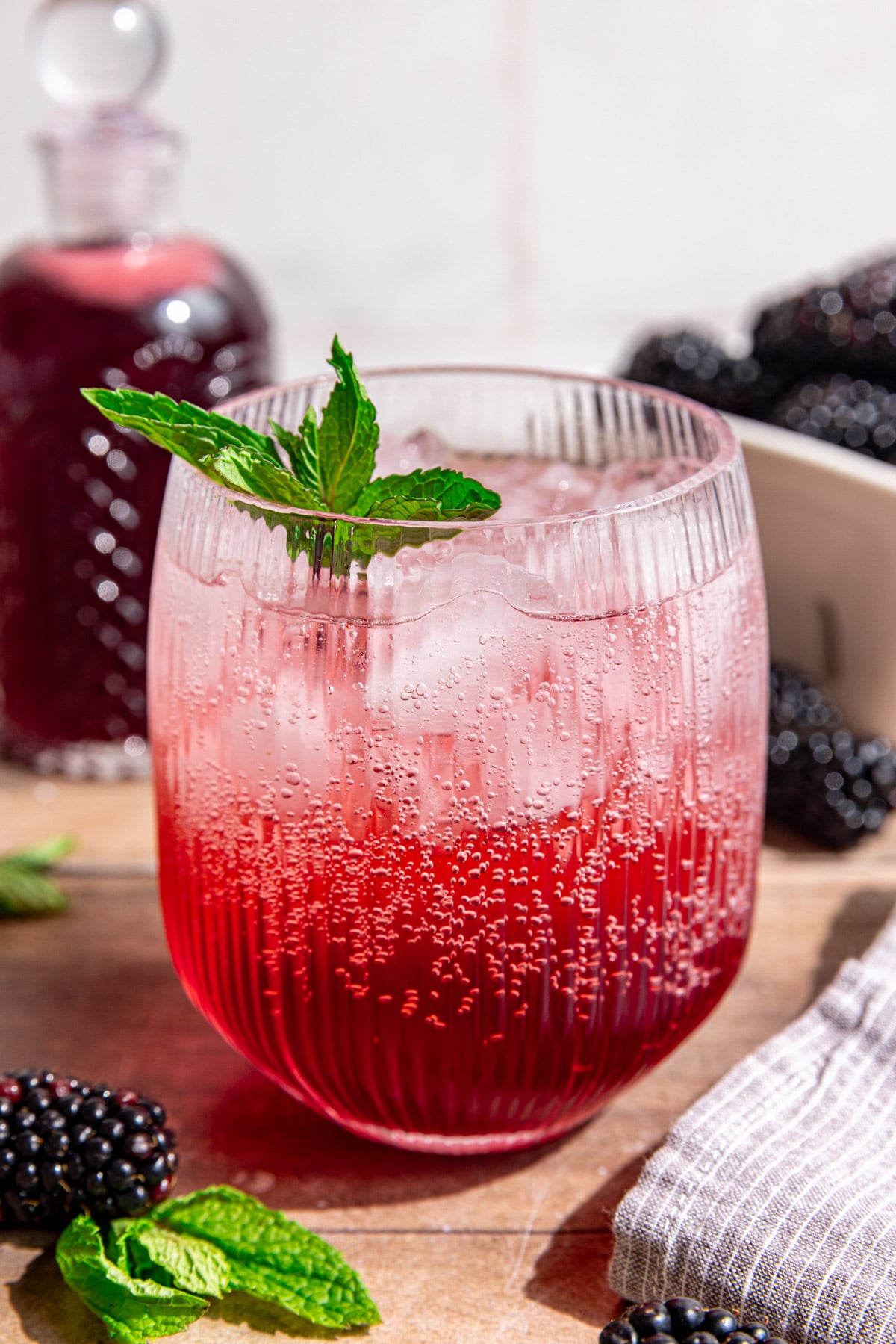 A blackberry shrub mocktail, garnished with fresh mint.