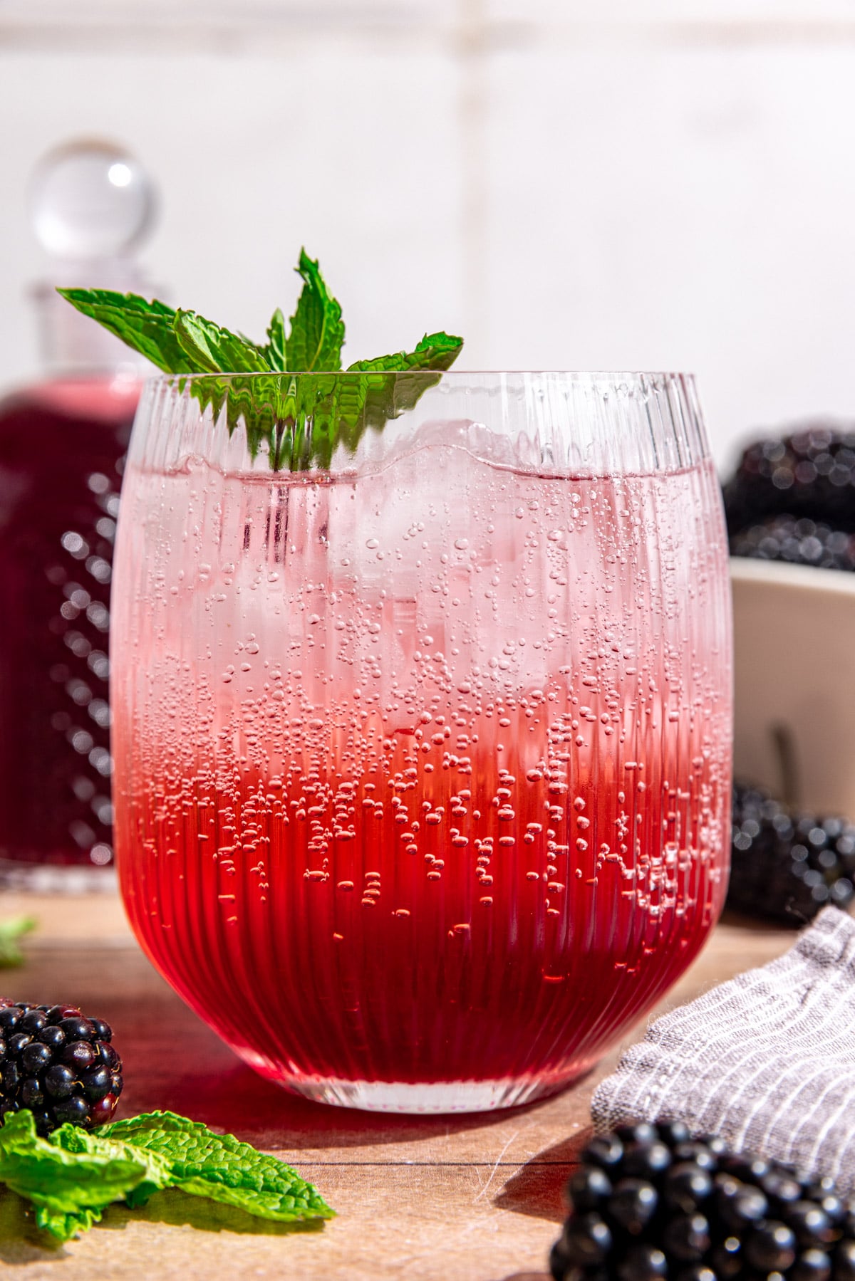 A blackberry shrub mocktail, garnished with fresh mint.