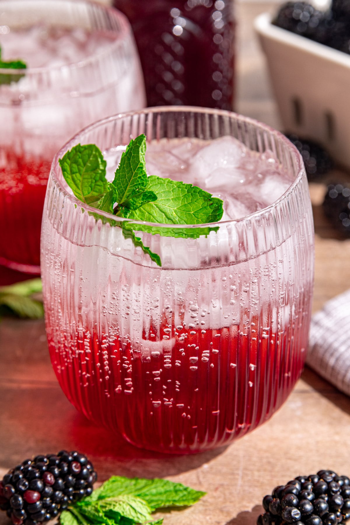 A blackberry shrub mocktail, garnished with fresh mint.