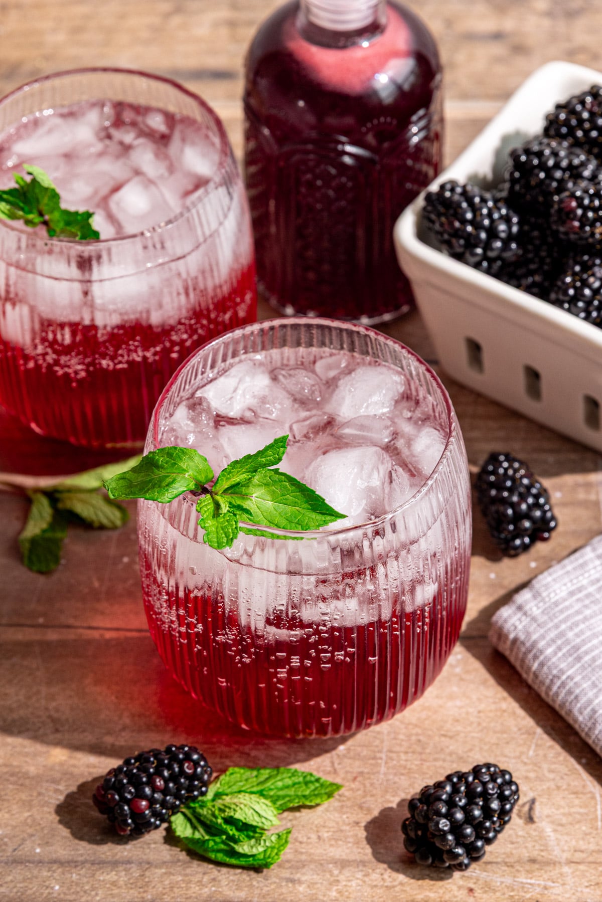 A blackberry shrub mocktail, garnished with fresh mint.