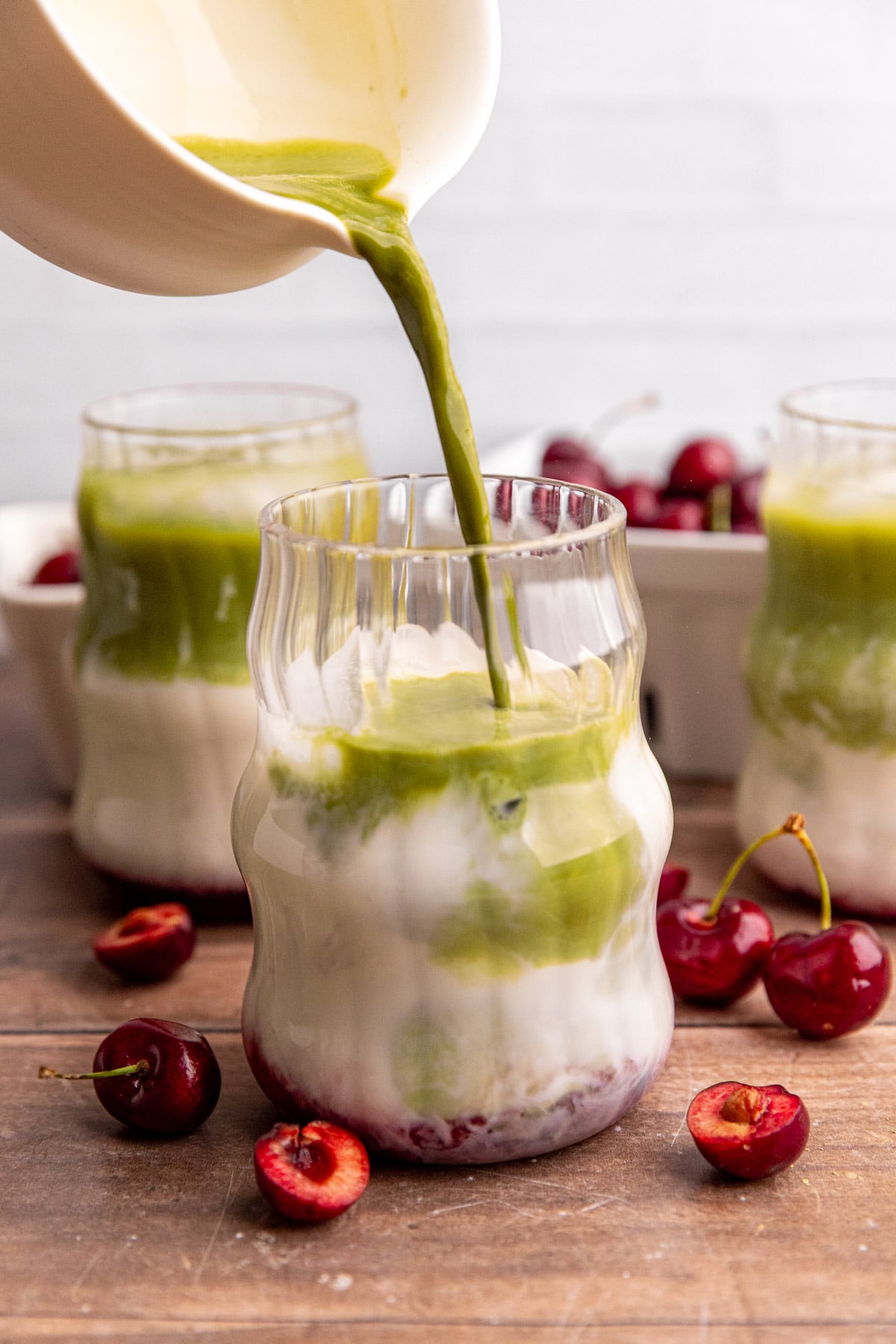 Matcha being poured into an iced matcha latte.