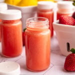 A small juice shot glass of strawberry lemon ginger wellness shots.