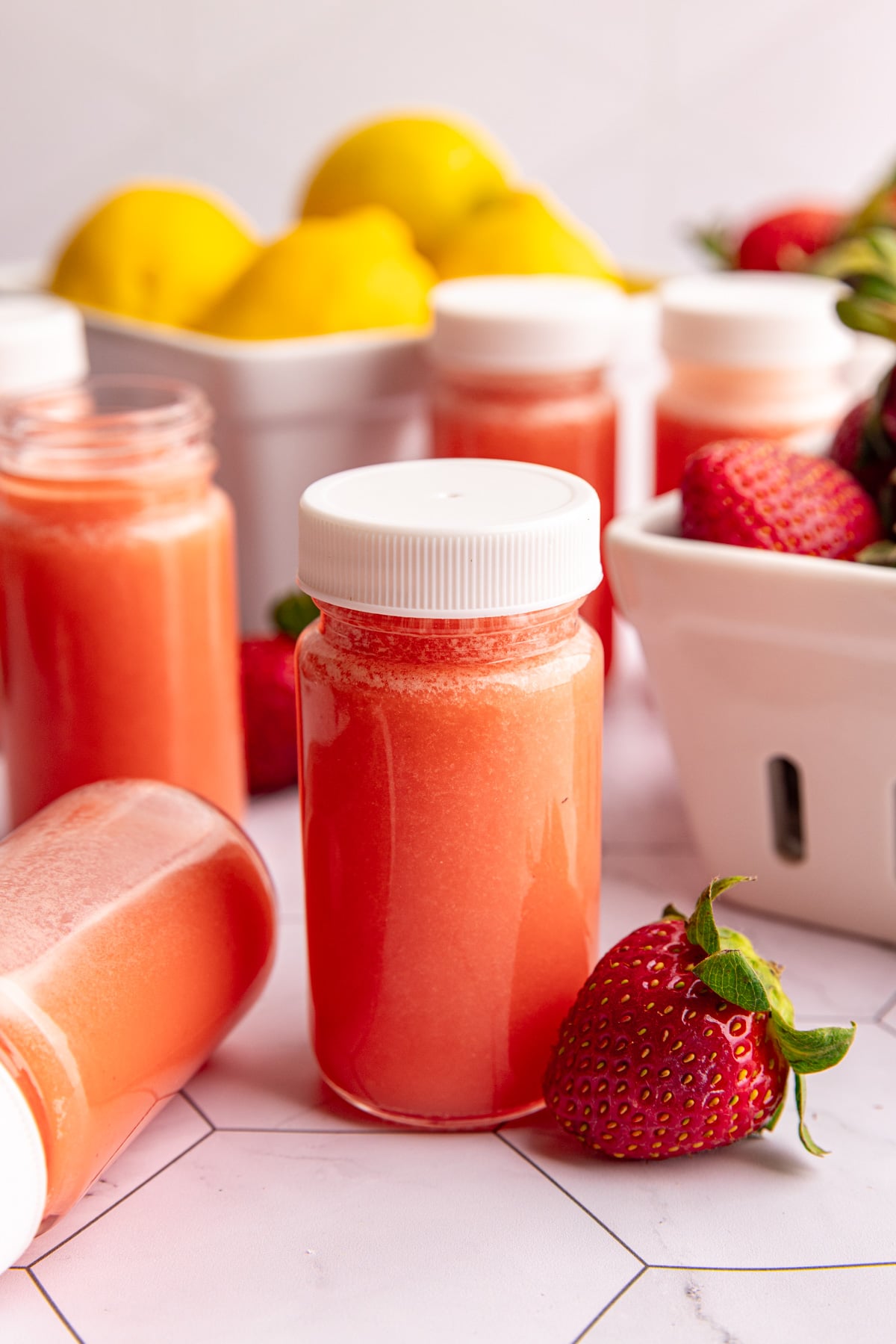 A small juice shot glass of strawberry lemon ginger wellness shots.