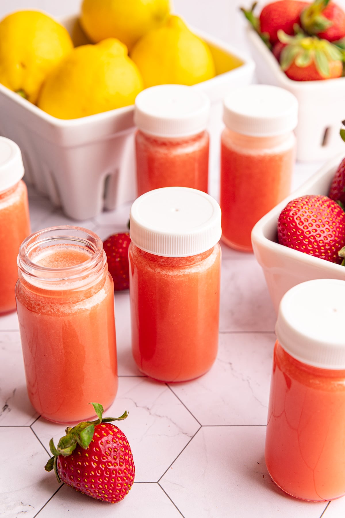 A small juice shot glass of strawberry lemon ginger wellness shots.