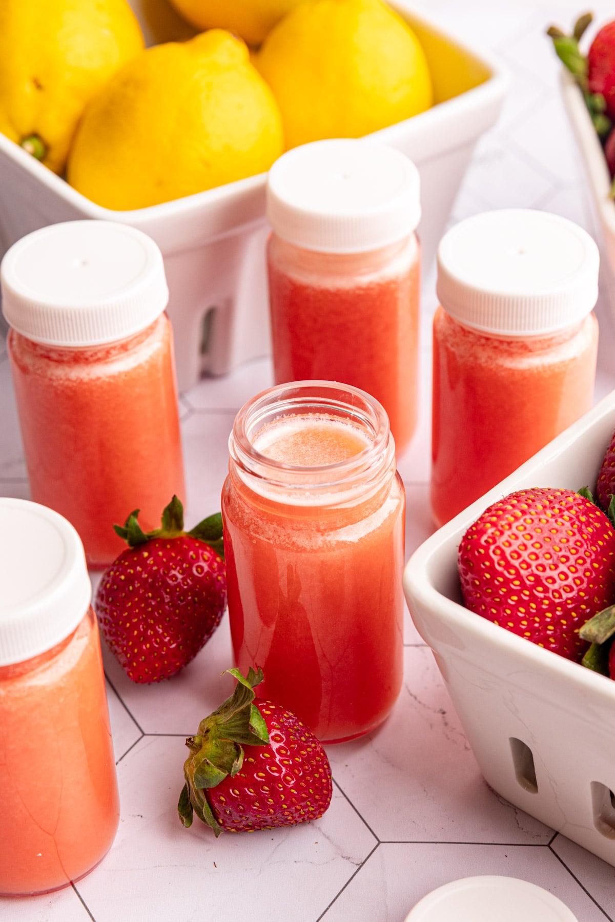 A small juice shot glass of strawberry lemon ginger wellness shots.