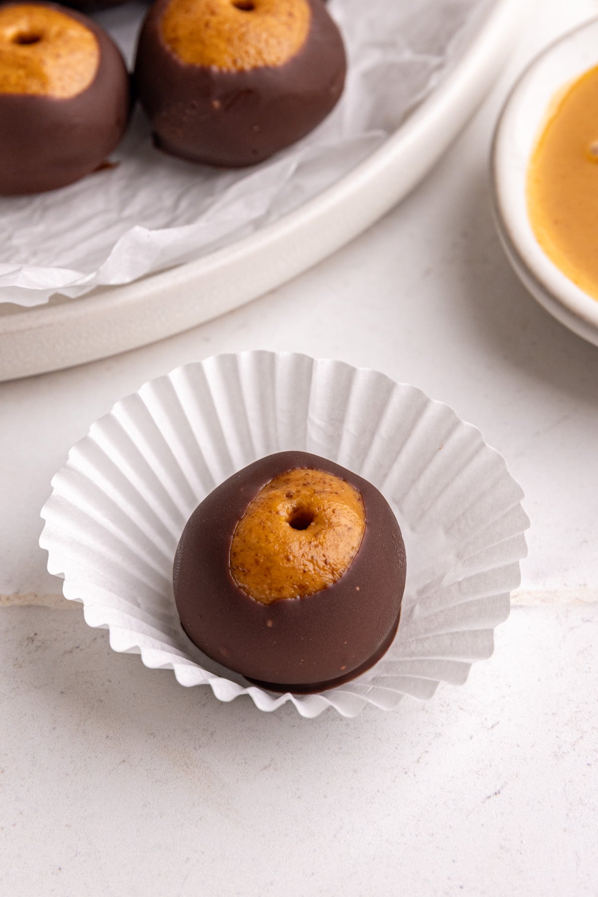 A vegan buckeye on a mini cupcake liner.