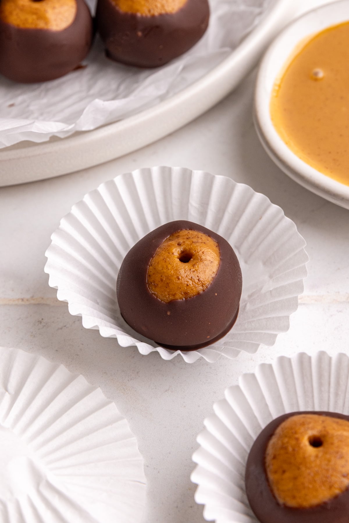 A vegan buckeye on a mini cupcake liner.
