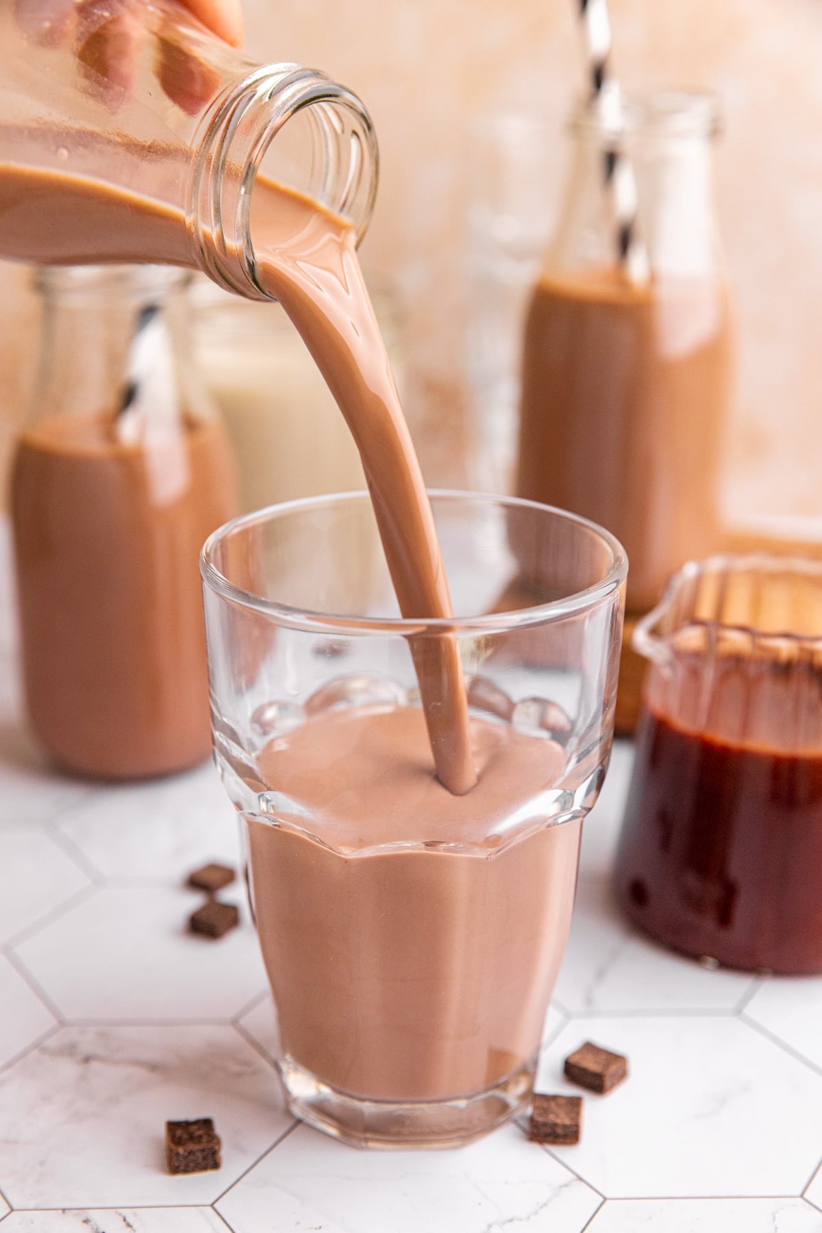Homemade chocolate milk being poured into a glass.
