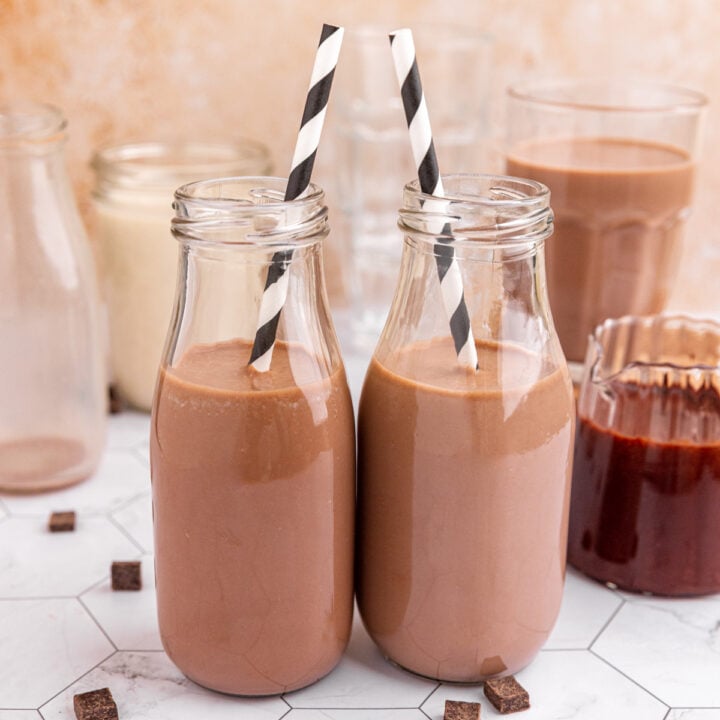 Two milk bottles of vegan chocolate milk.