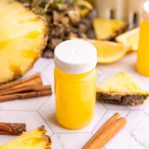 A small juice bottle of pineapple cinnamon wellness shot.