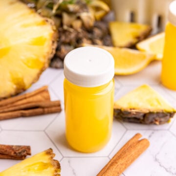 A small juice bottle of pineapple cinnamon wellness shot.