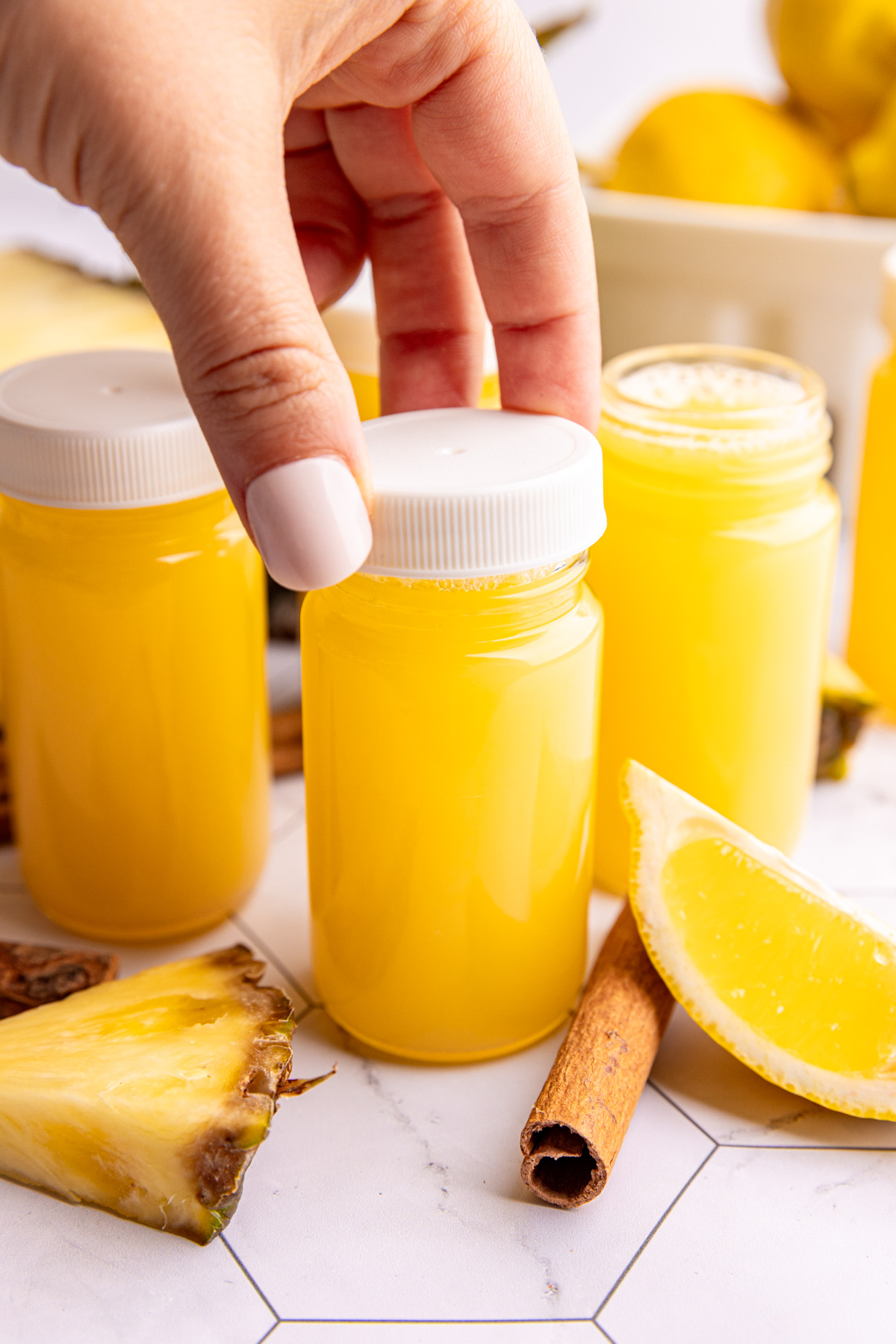 A juice shot bottle of pineapple cinnamon wellness shot.