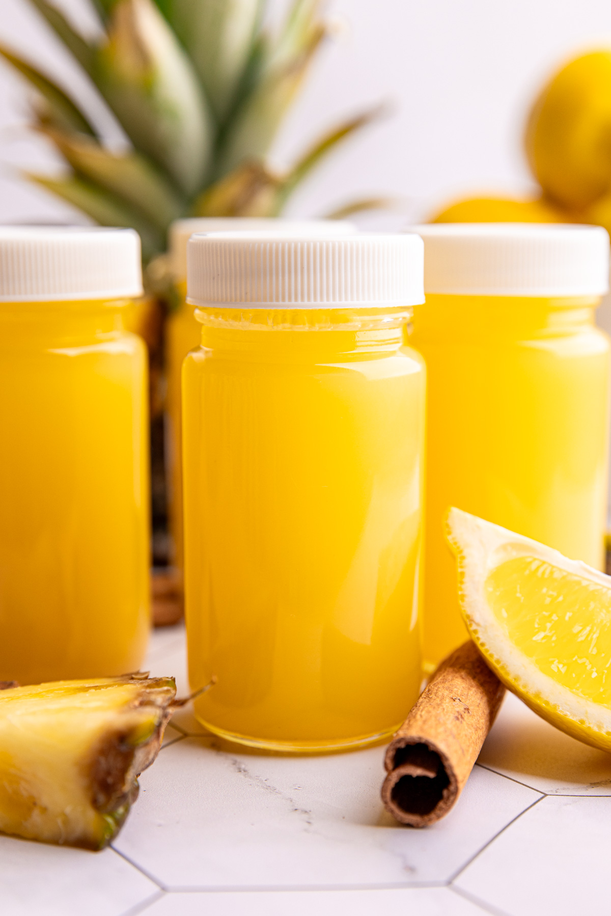 A juice shot bottle of pineapple cinnamon wellness shot.