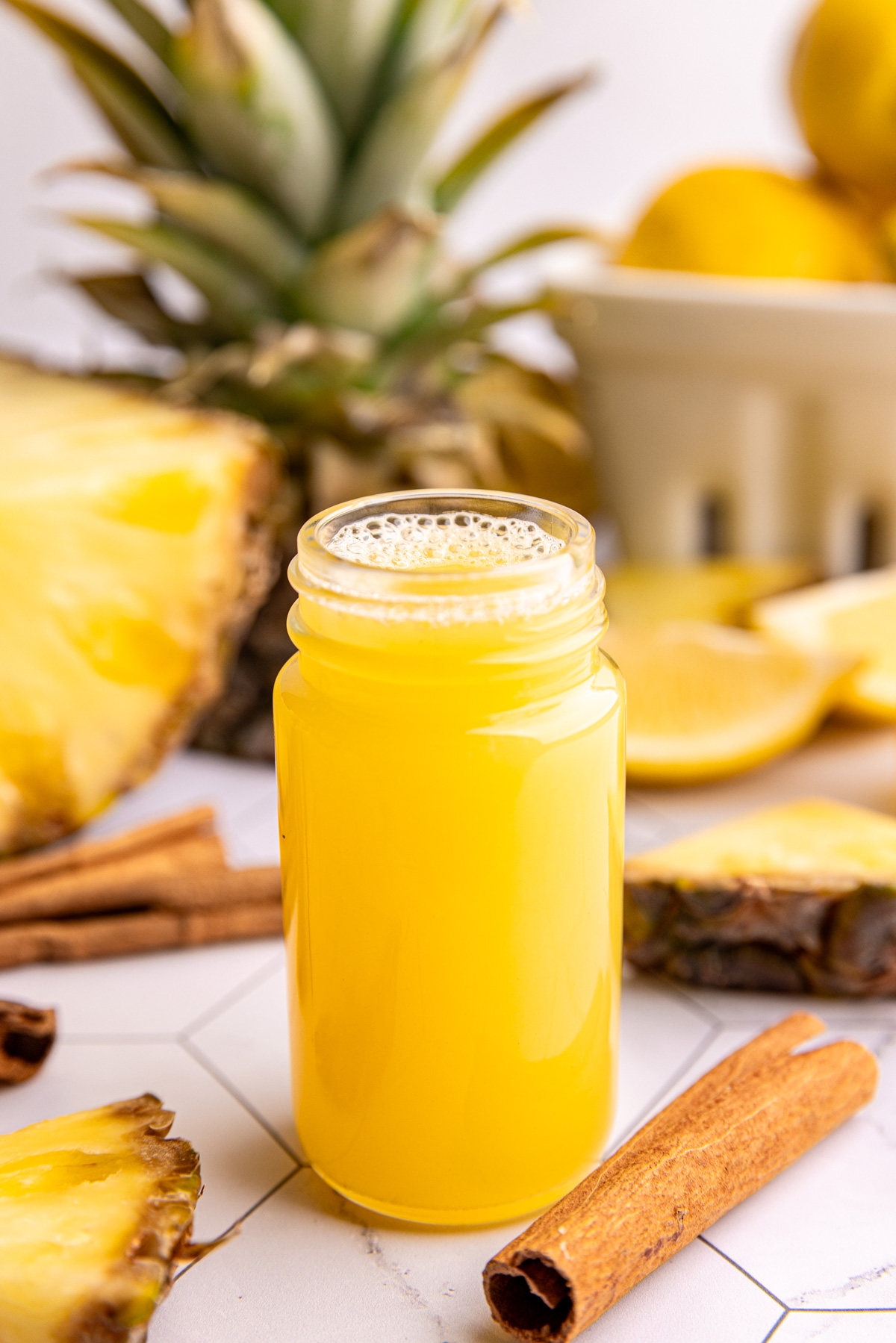A juice shot bottle of pineapple cinnamon wellness shot.