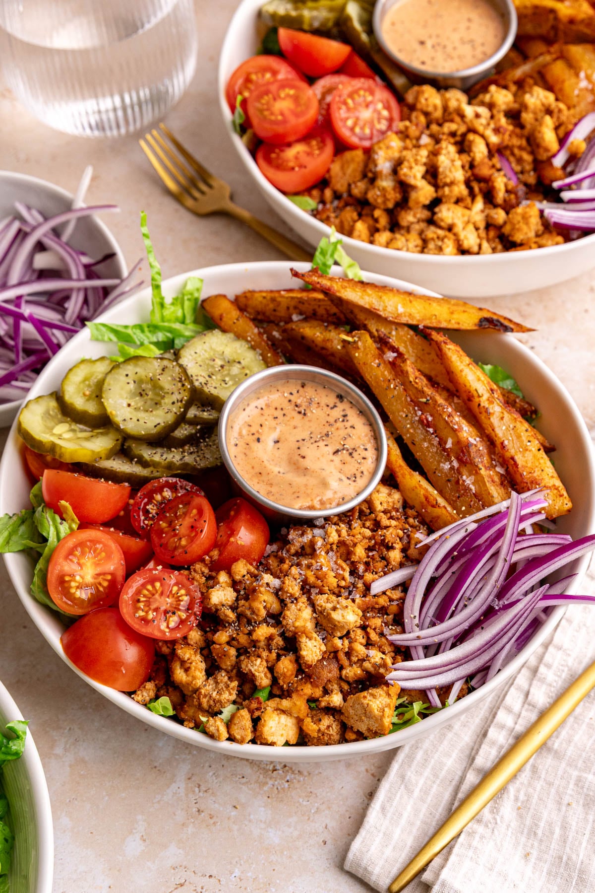 A vegan burger bowl, with a napkin and fork, ready to eat.