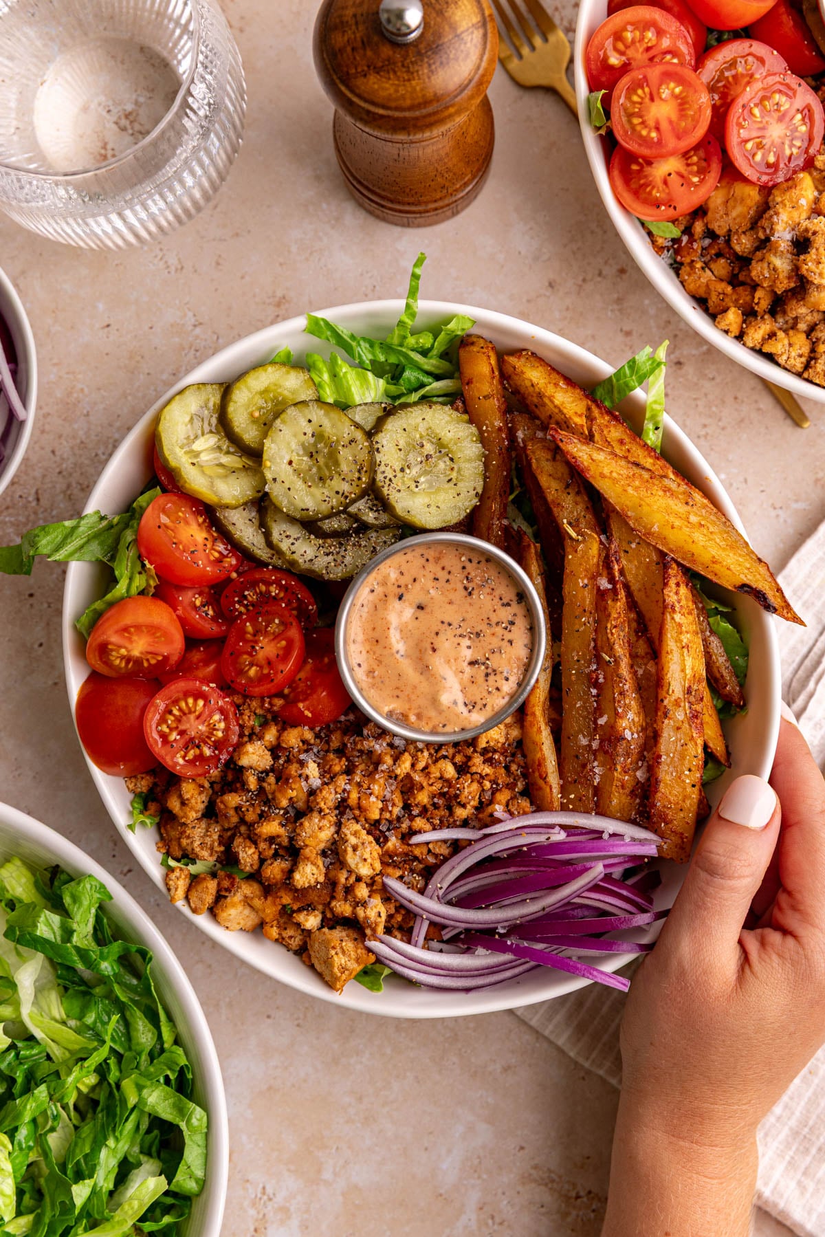 A vegan burger bowl, with a napkin and fork, ready to eat.
