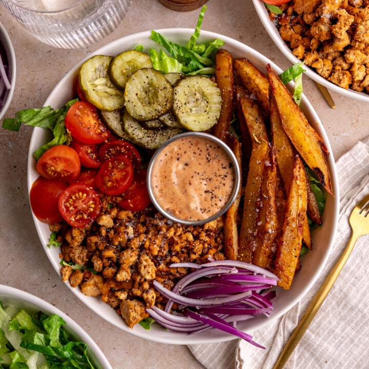 A vegan burger bowl, with a napkin and fork, ready to eat.