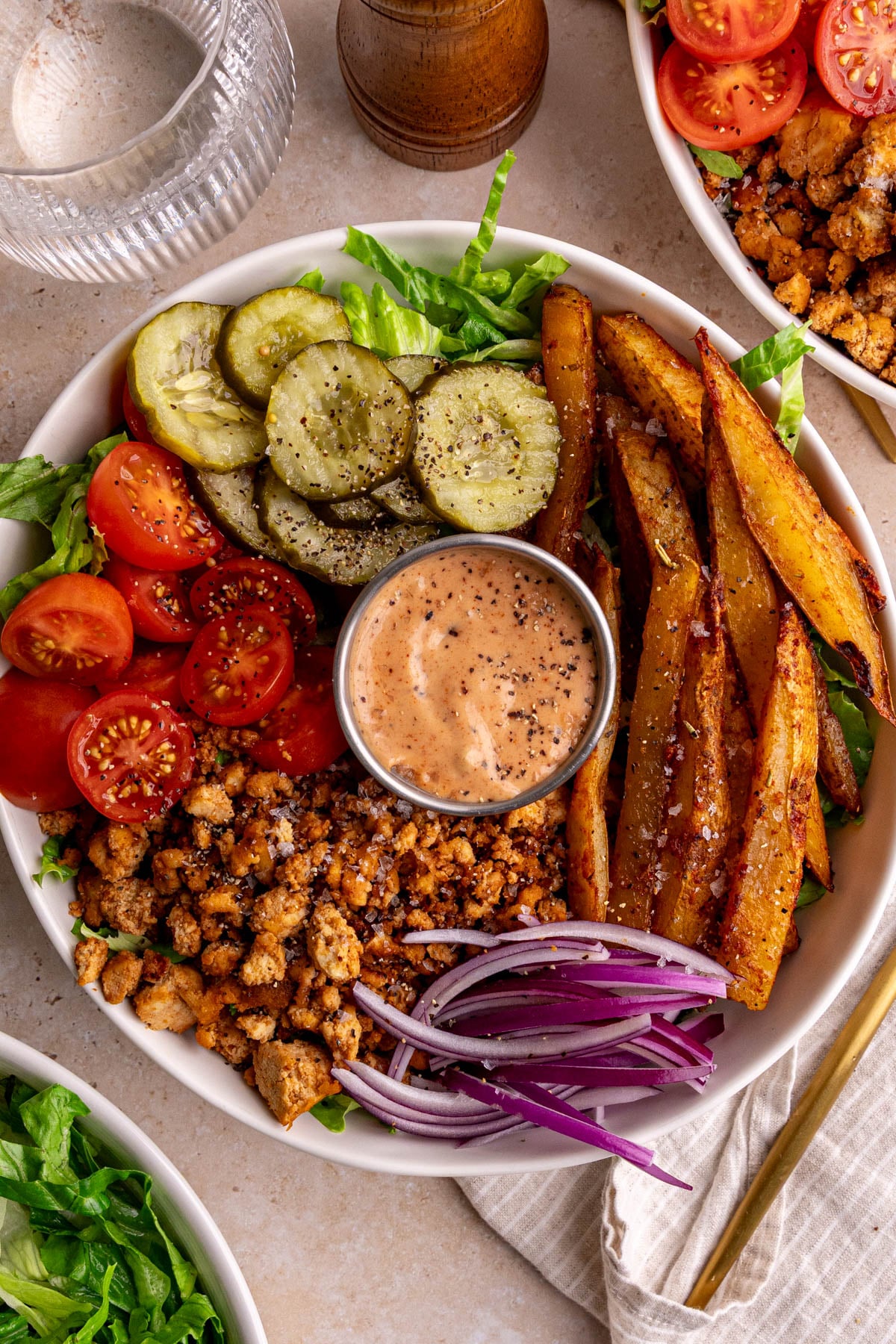 A vegan burger bowl, with a napkin and fork, ready to eat.