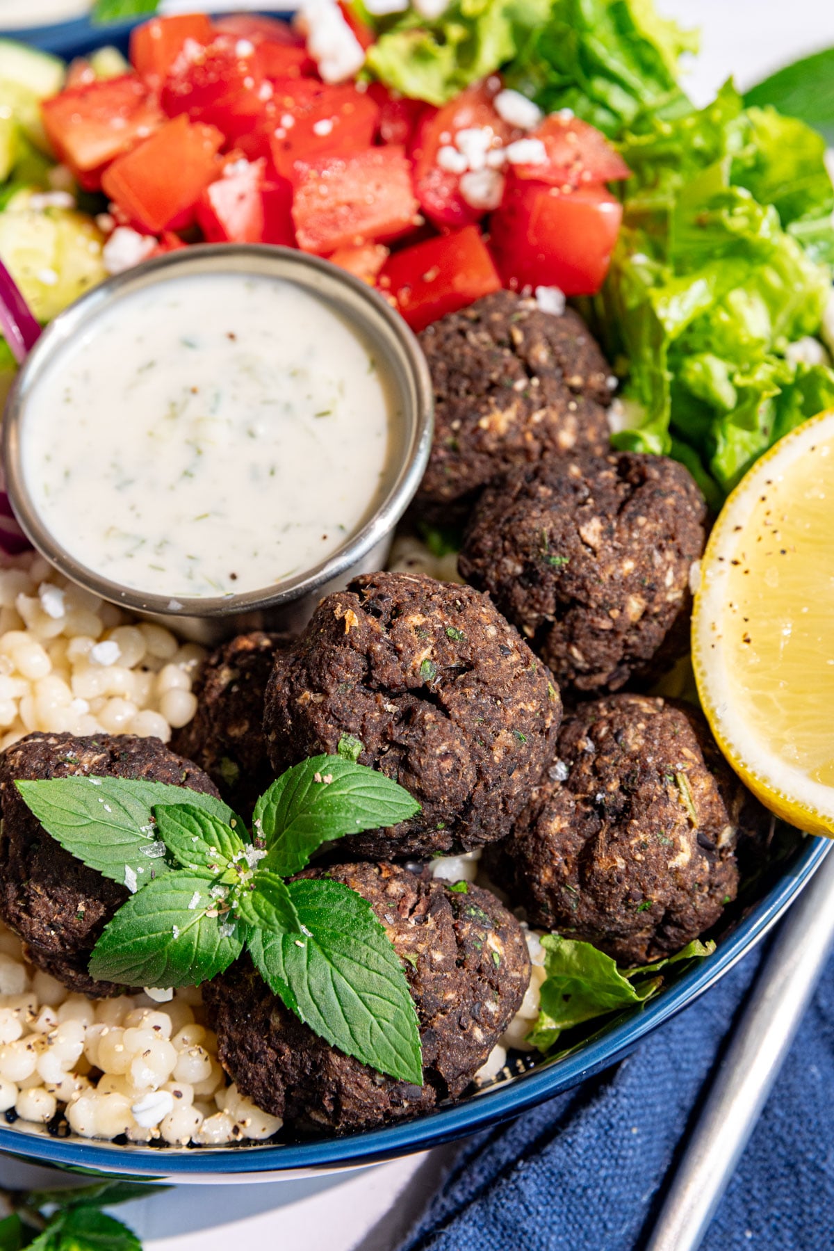 A close up view of the vegan Greek meatballs in a vegan Greek couscous bowl.