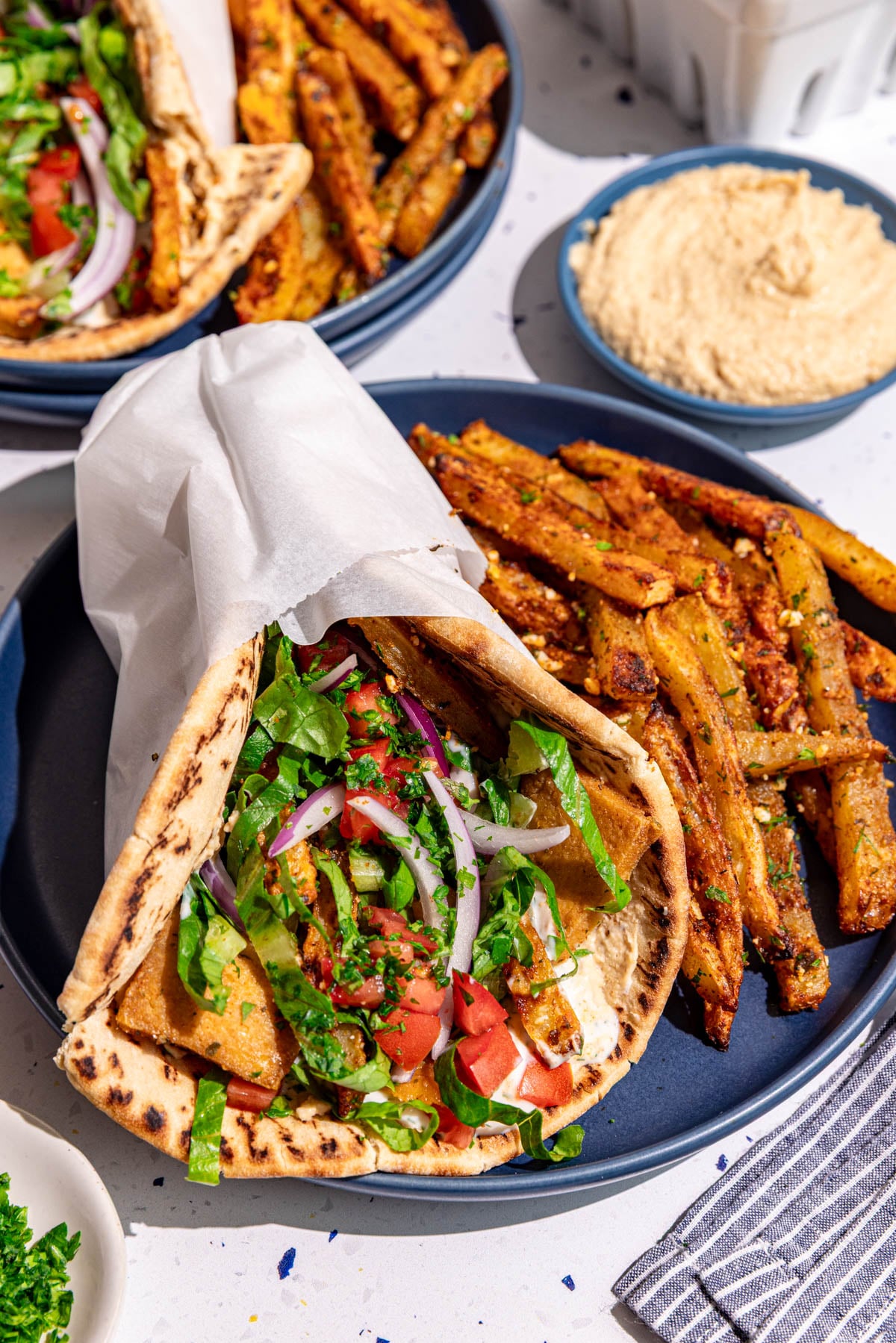 A plate with a vegan gyro and loaded greek fries.