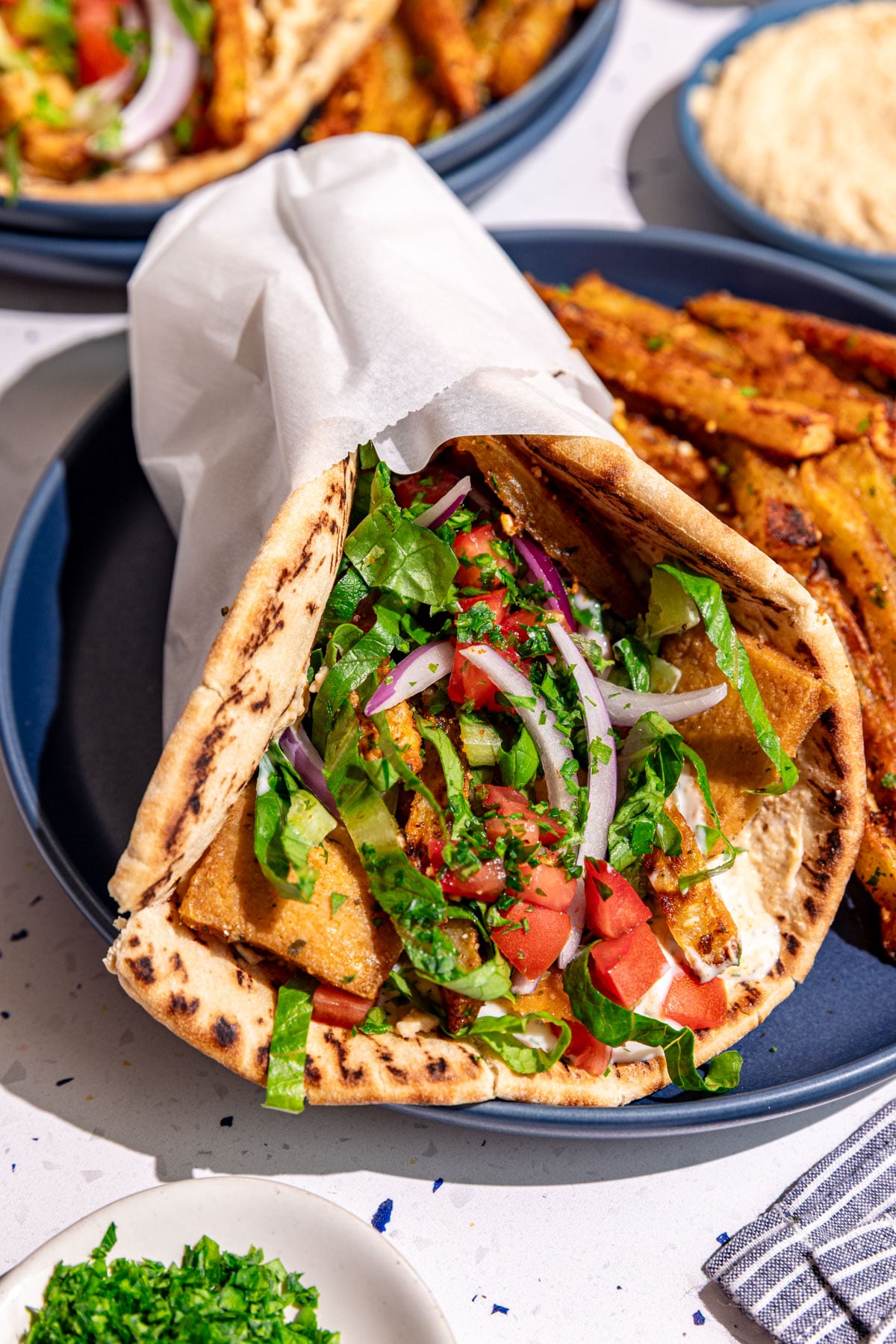 A plate with a vegan gyro and loaded greek fries.