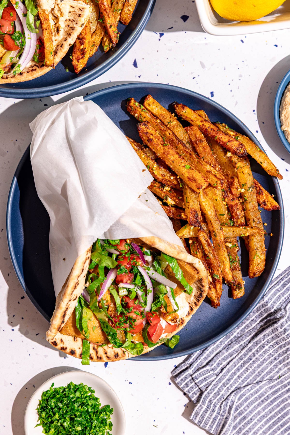 A plate with a vegan gyro and loaded greek fries.
