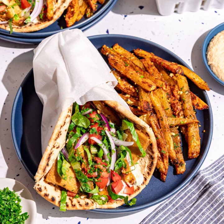 A plate with a vegan gyro and loaded greek fries.
