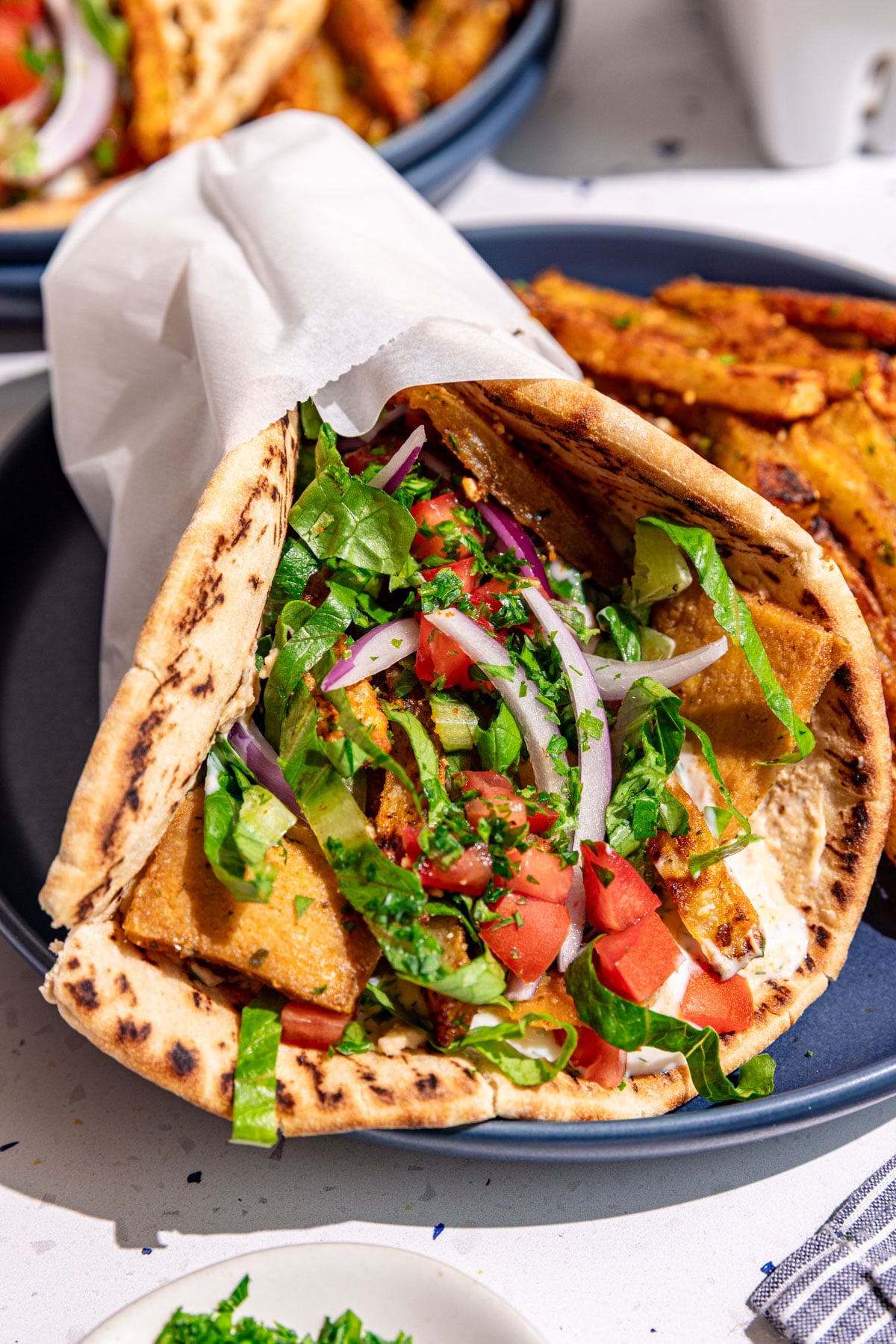 A plate with a vegan gyro and loaded greek fries.