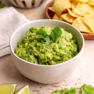 A bowl of the best ever guacamole, topped with cilantro.