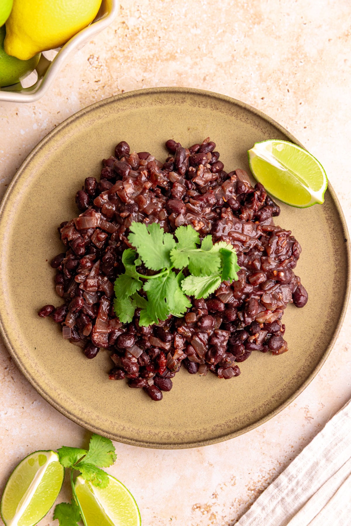 A plate of homemade chipotle style black beans, garnished with fresh cilantro.