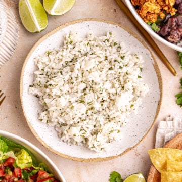 A bowl of homemade cilantro lime rice, next to two Chipotle style bowls.