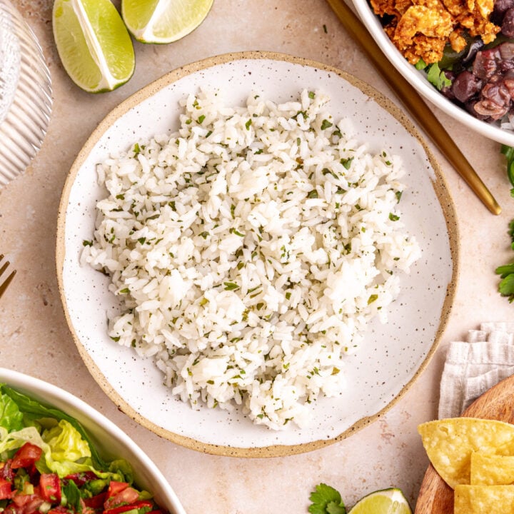 A bowl of homemade cilantro lime rice, next to two Chipotle style bowls.