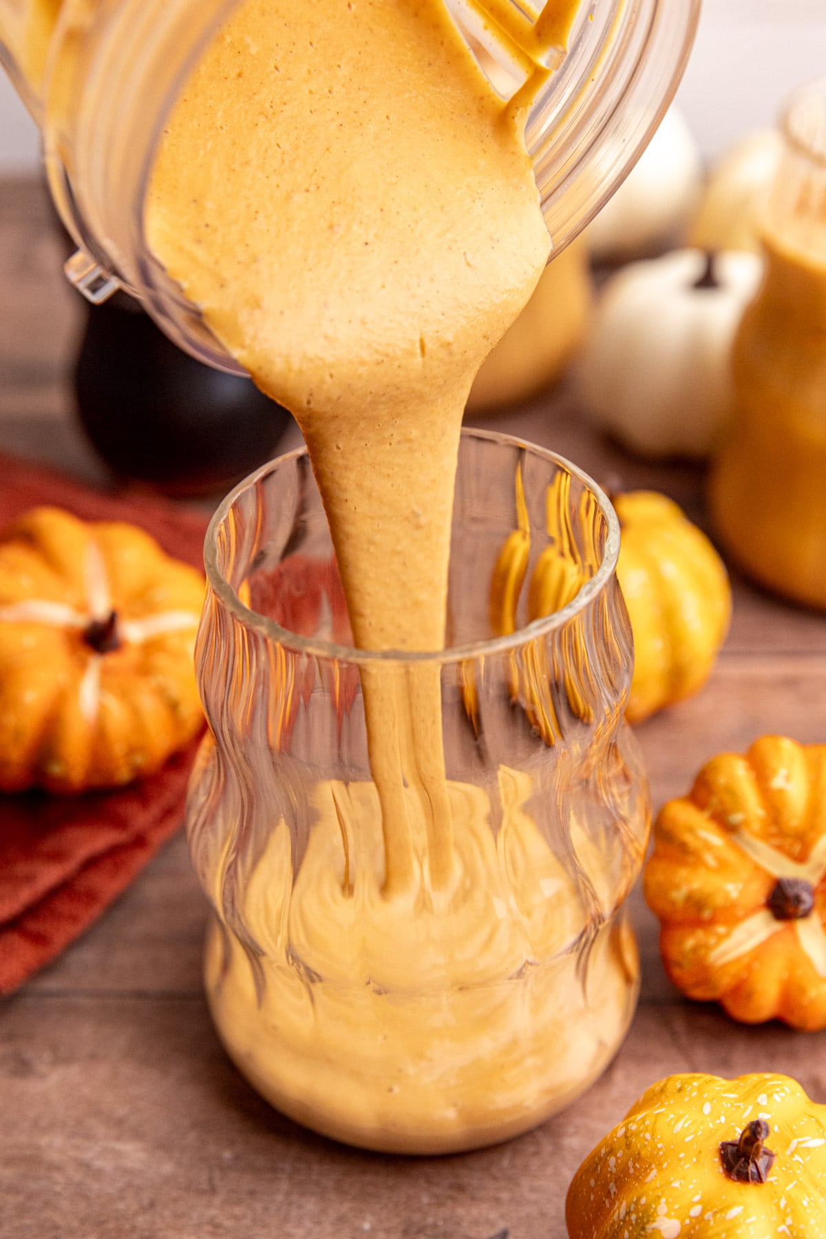 A pumpkin banana smoothie being poured into a glass.