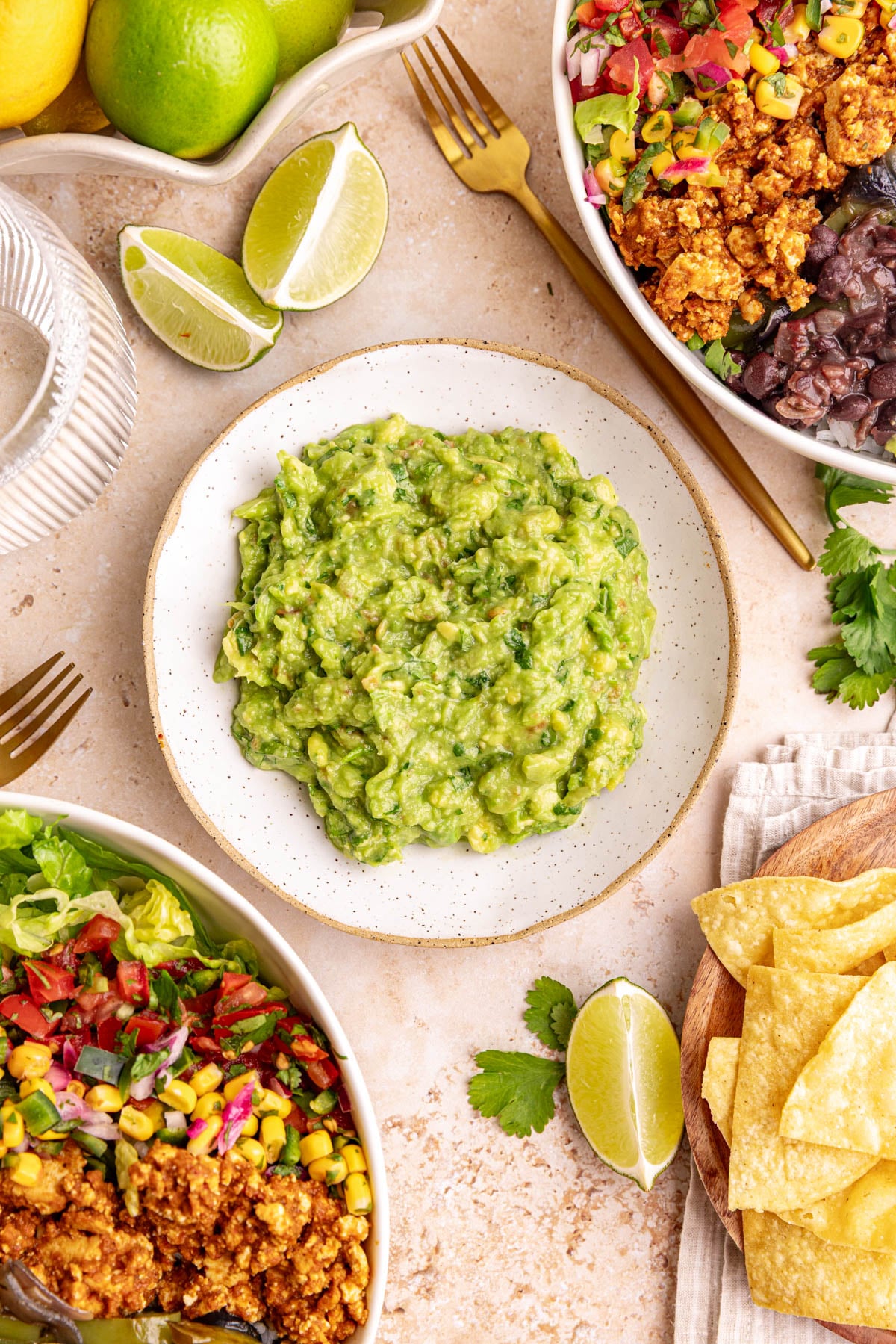 A bowl of the best ever guacamole, next to two chipotle bowls.