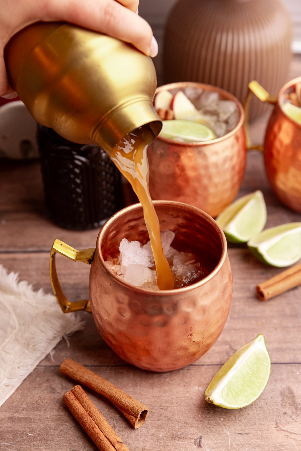The apple cider mixture being poured into a mule glass.