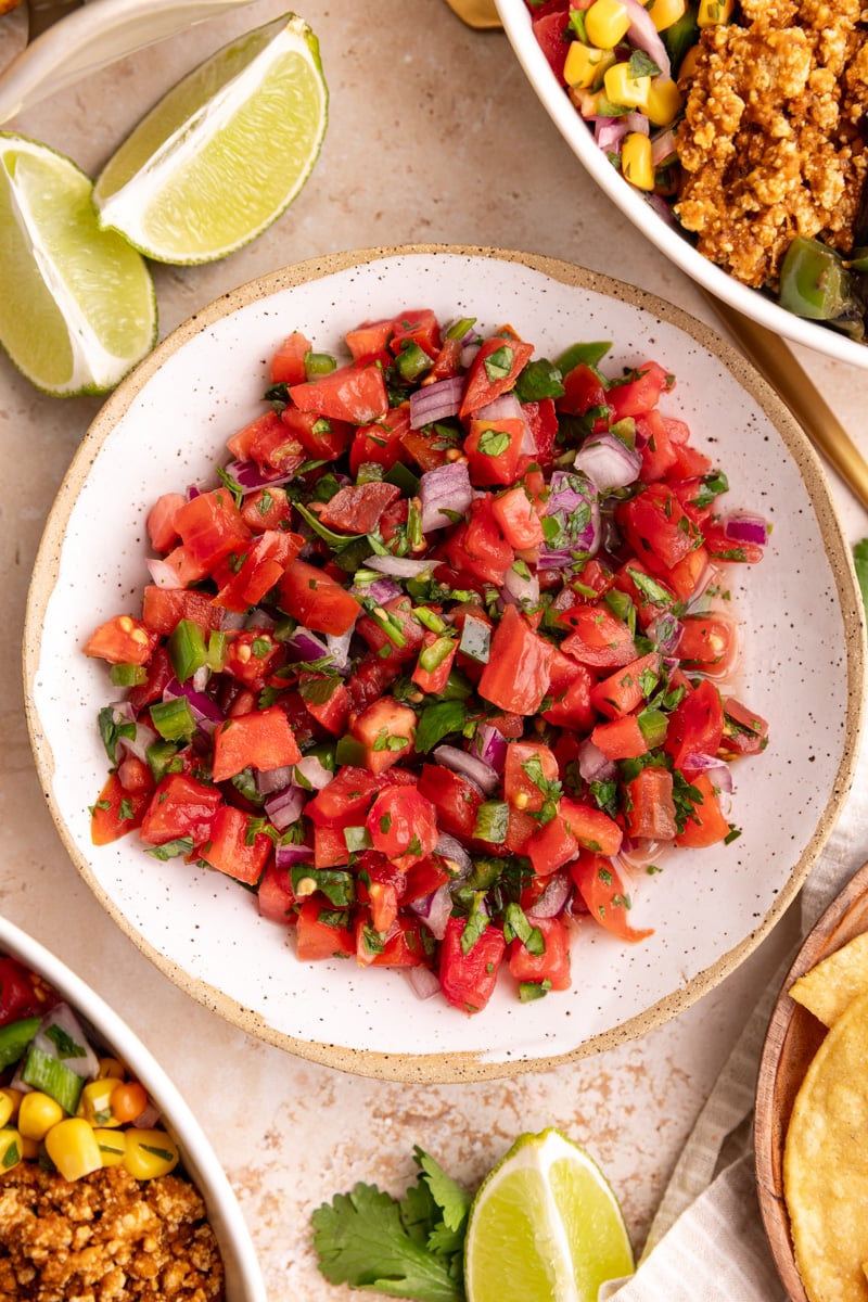A bowl of Homemade tomato salsa, next to two chipotle bowls.
