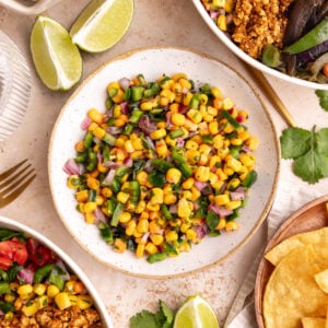 A bowl of Homemade chili corn salsa, next to two chipotle bowls.