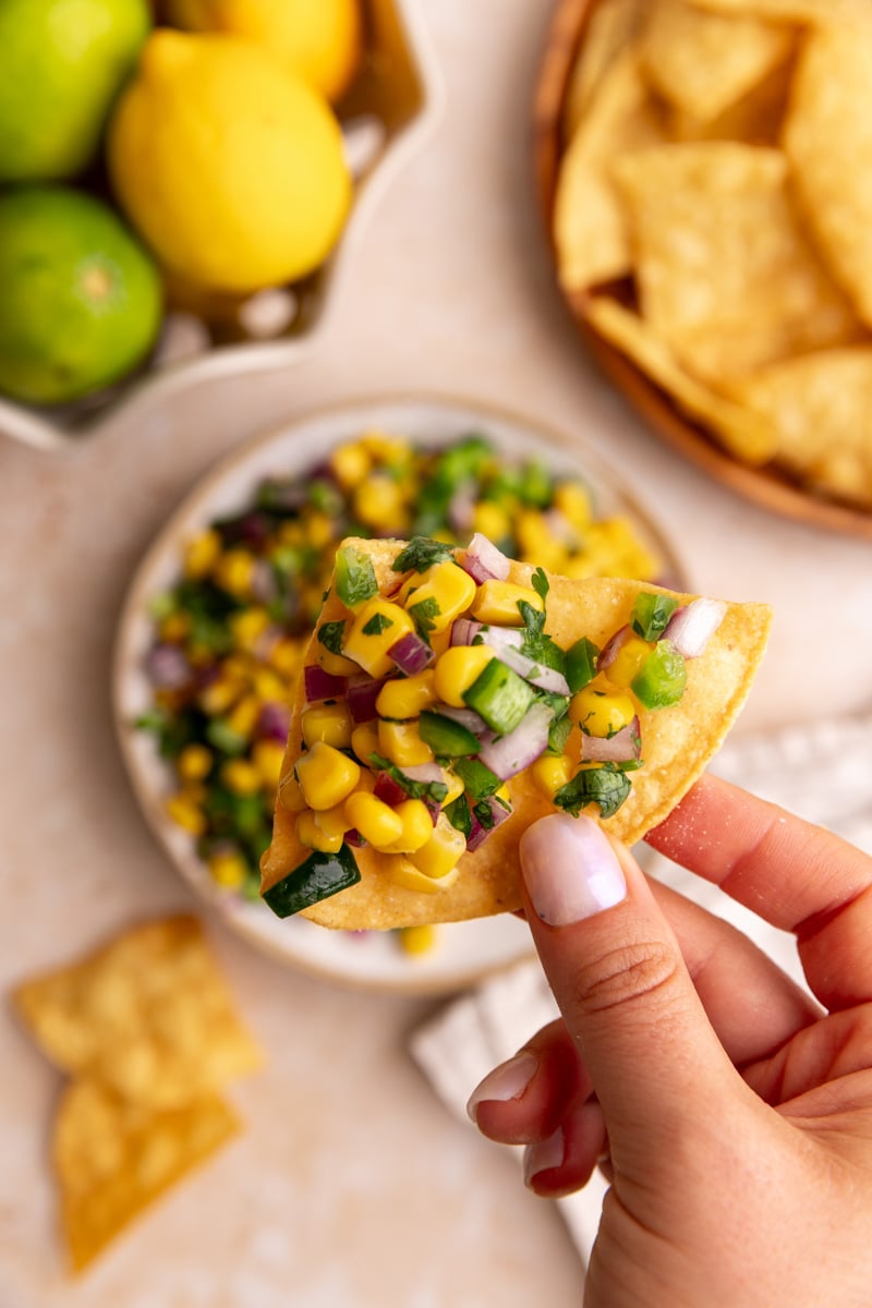 A chip scooping a bit of Homemade Chili Corn Salsa