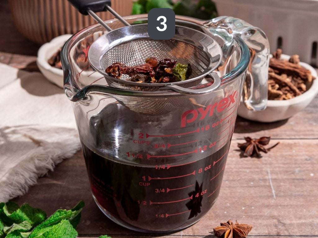 Homemade root beer step 3 - strain and bottle the syrup.
