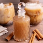 A bottle of horchata syrup, next to a few horchata shaken espresso drinks.