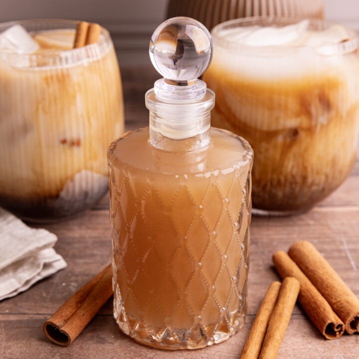 A bottle of horchata syrup, next to a few horchata shaken espresso drinks.