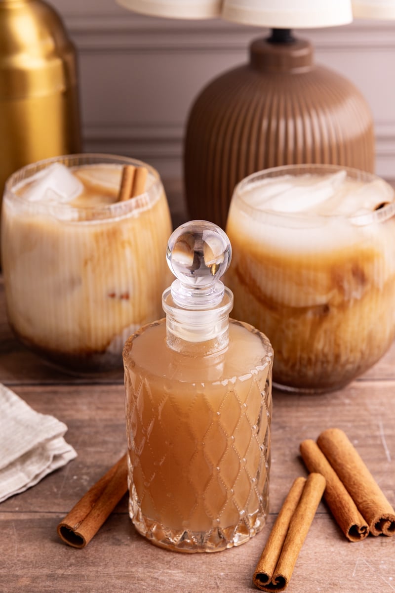 A bottle of horchata syrup, next to a few horchata shaken espresso drinks.