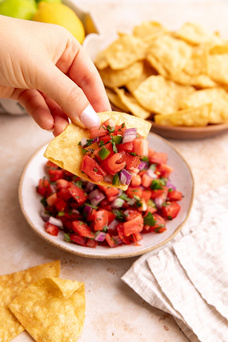 A chip scooping a bit of Homemade tomato salsa
