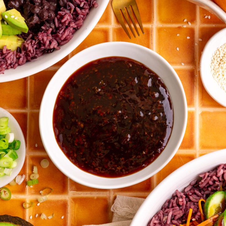 A bowl of bibibop-style teriyaki sauce, next to two bibibop bowls.